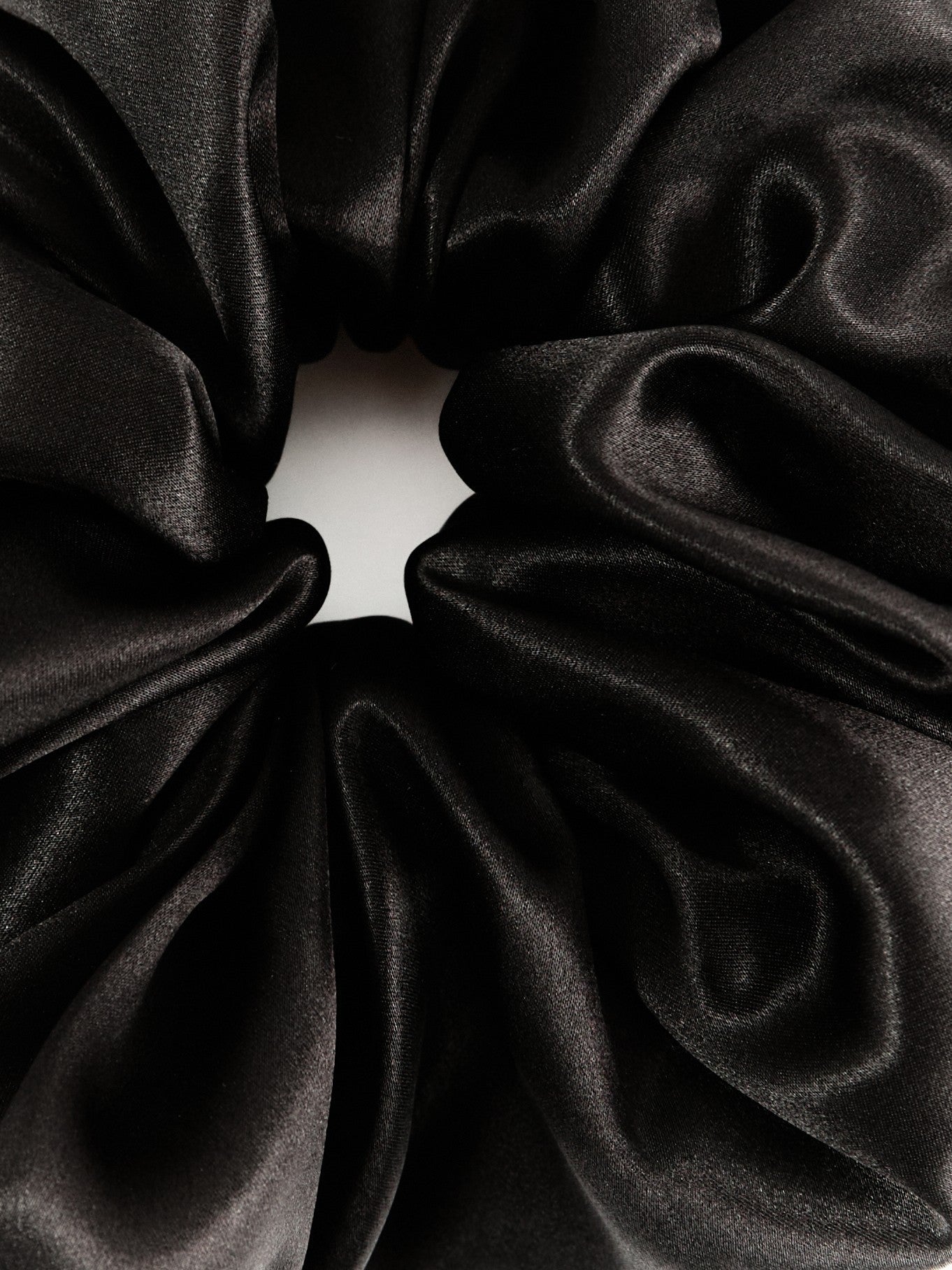 Oversized silk scrunchie in Black - packshot, on material - CONTOUROSE